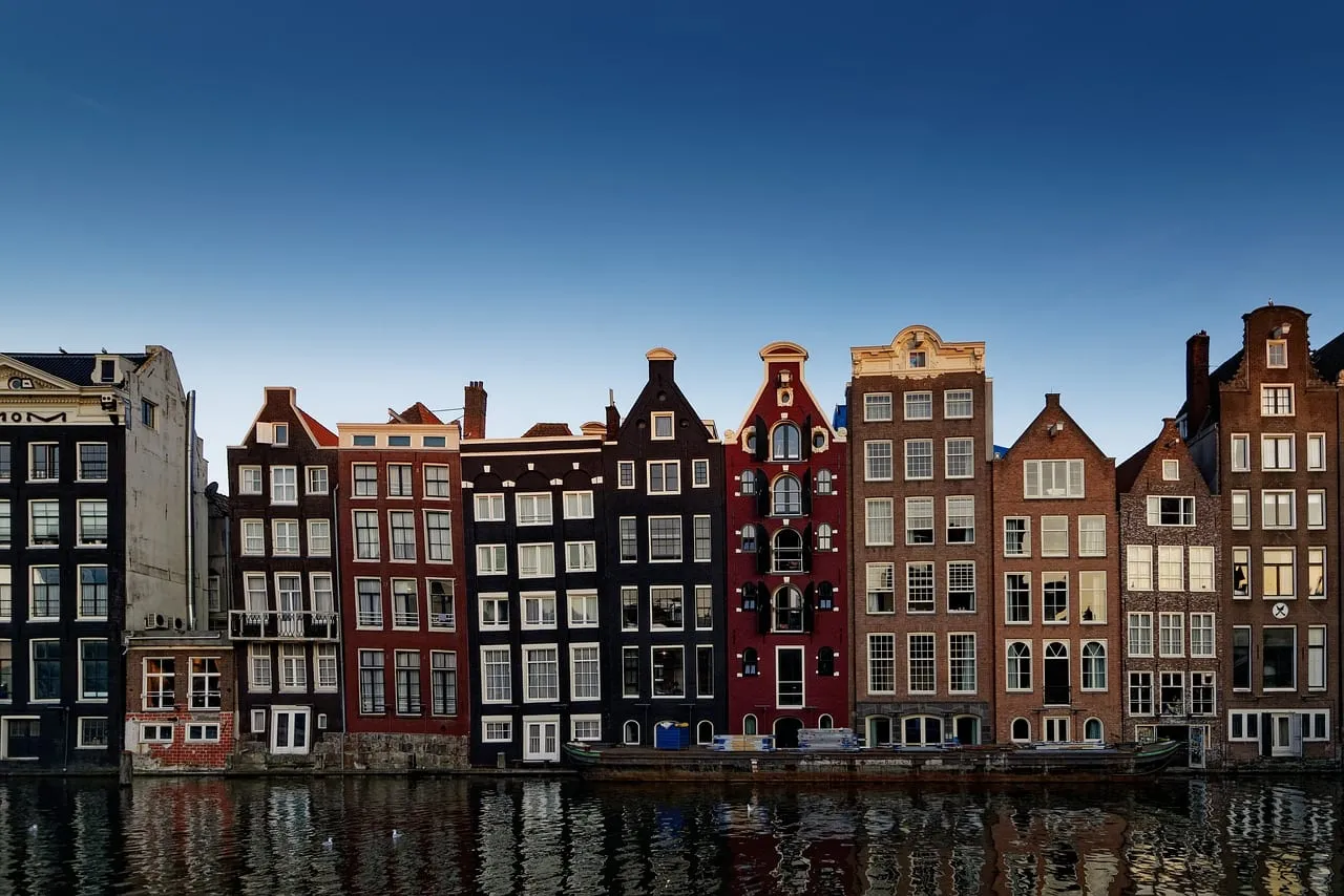The leaning gabled houses of the Damrak reflected in the water