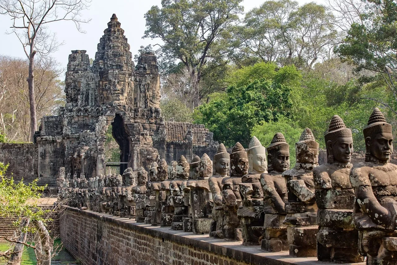 A gate of Angkor Thom with rows of stone figures along the causeway