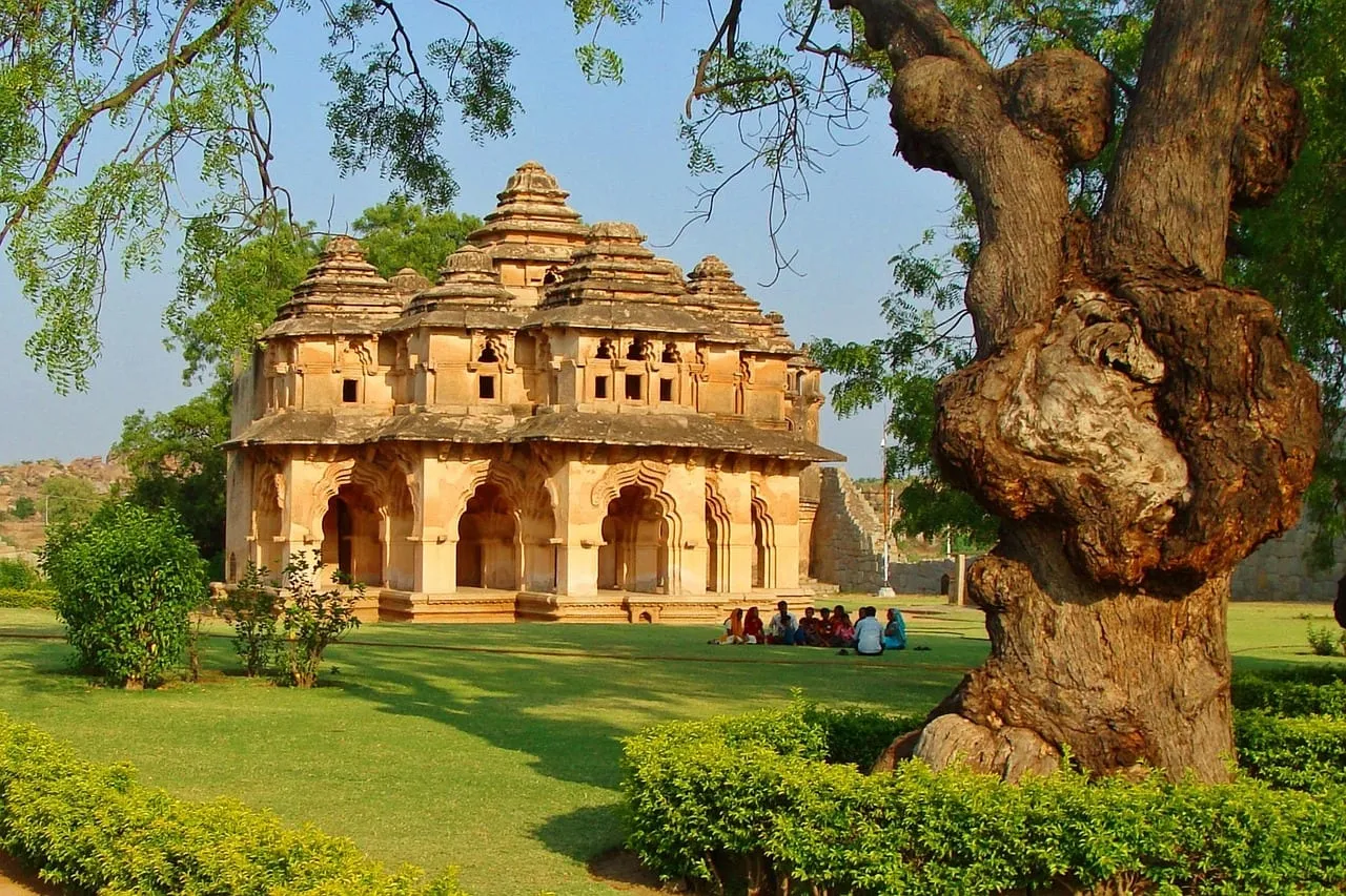 The Lotus Mahal with its tiered arches, beside a large old tree