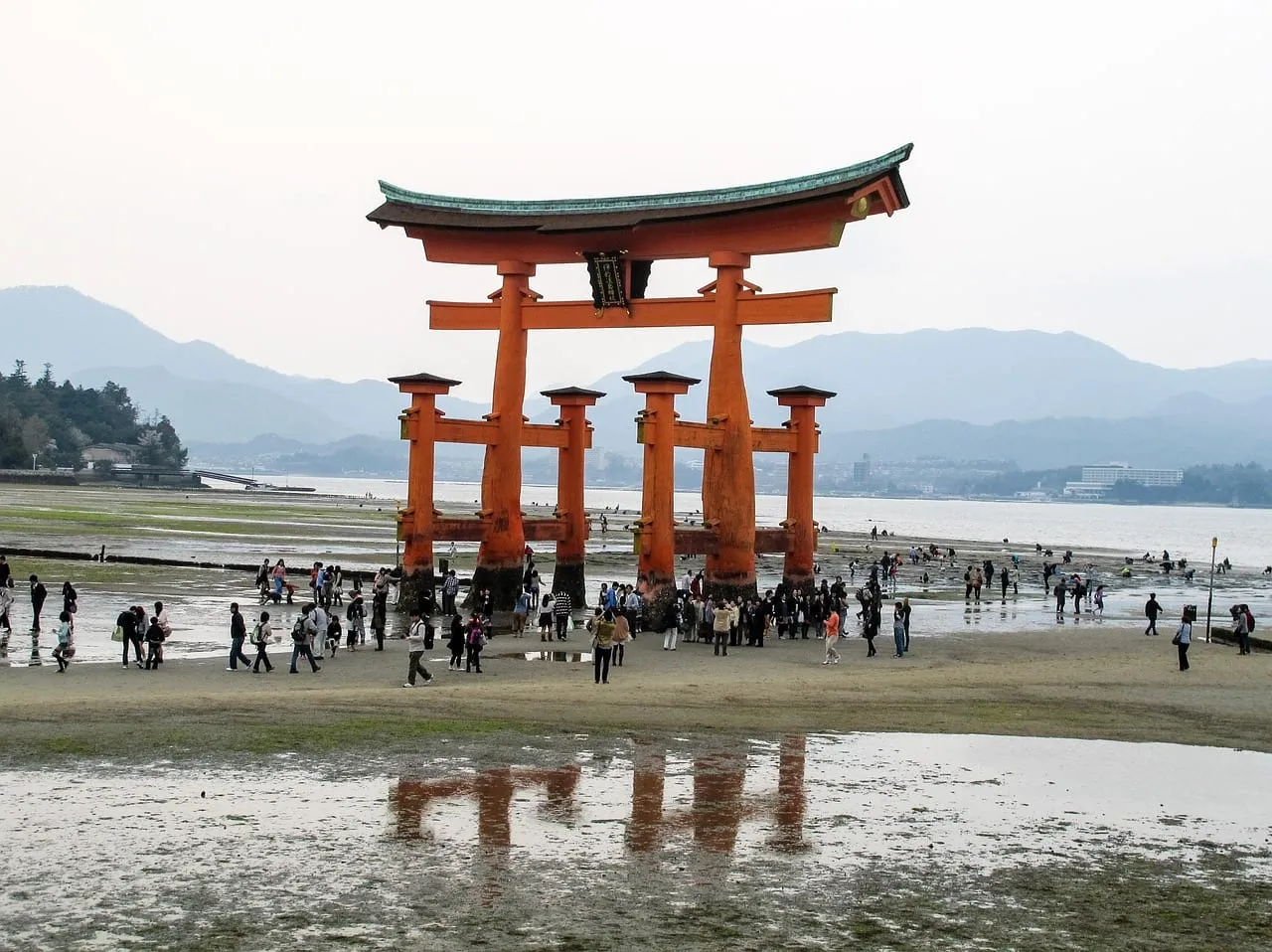 Visitors walking to the torii at low tide