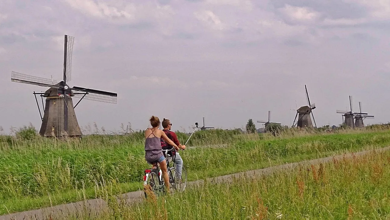 Cyclists on the path between the windmills