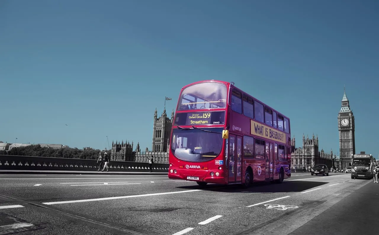 A red double-decker bus passing the Houses of Parliament
