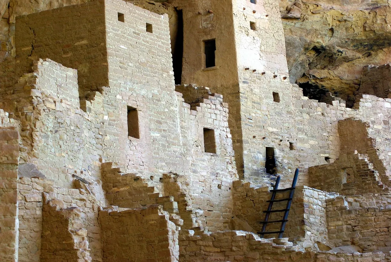 Stone towers and a ladder in a cliff dwelling