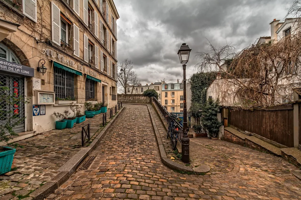 A cobbled lane in Montmartre with old lamps and houses