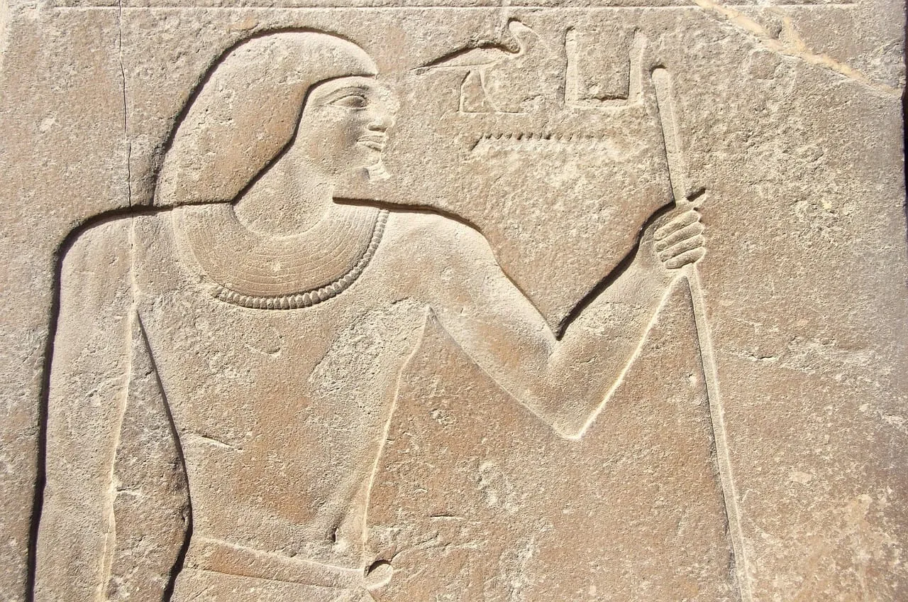 A carved relief of a man holding a staff