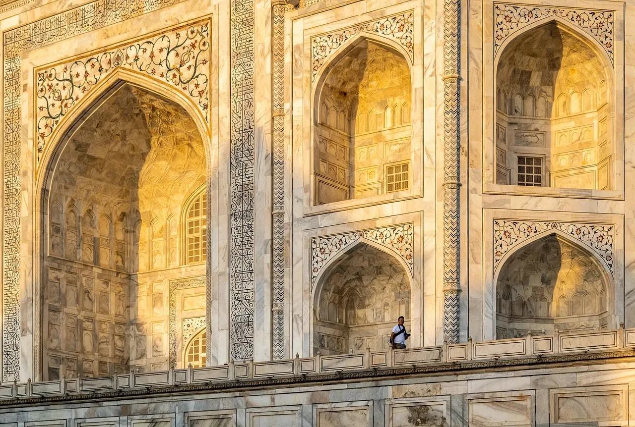 Carved marble arches of the Taj Mahal in warm light