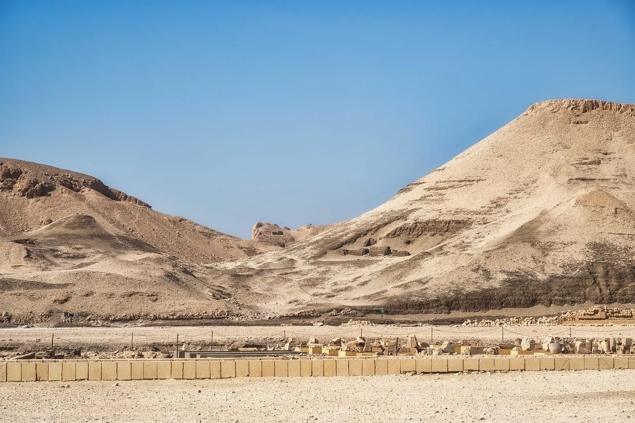 A bare desert valley under a pyramid-shaped peak