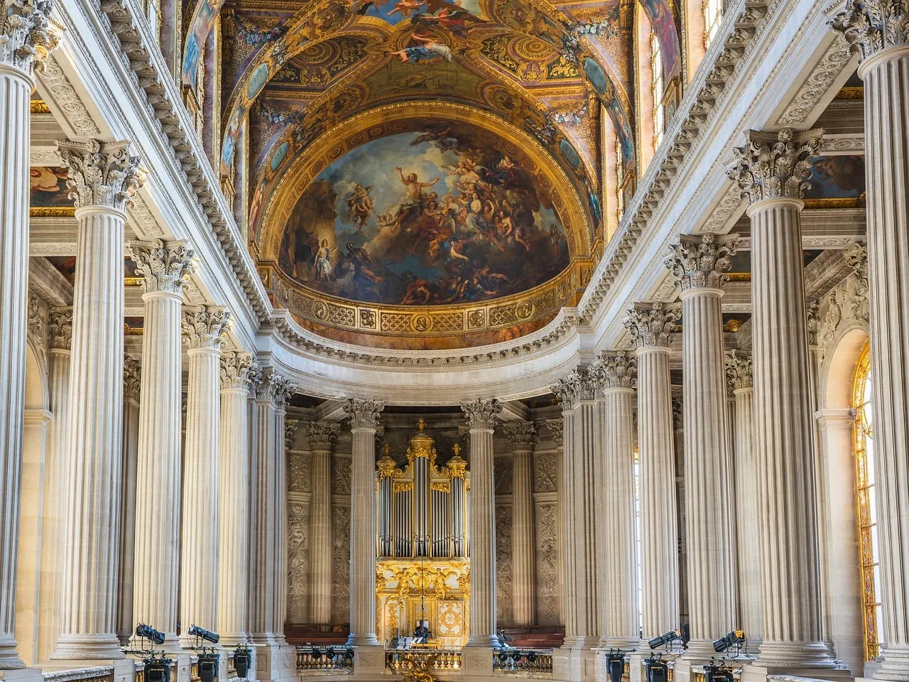 The Royal Chapel, with white columns and a painted ceiling above the organ