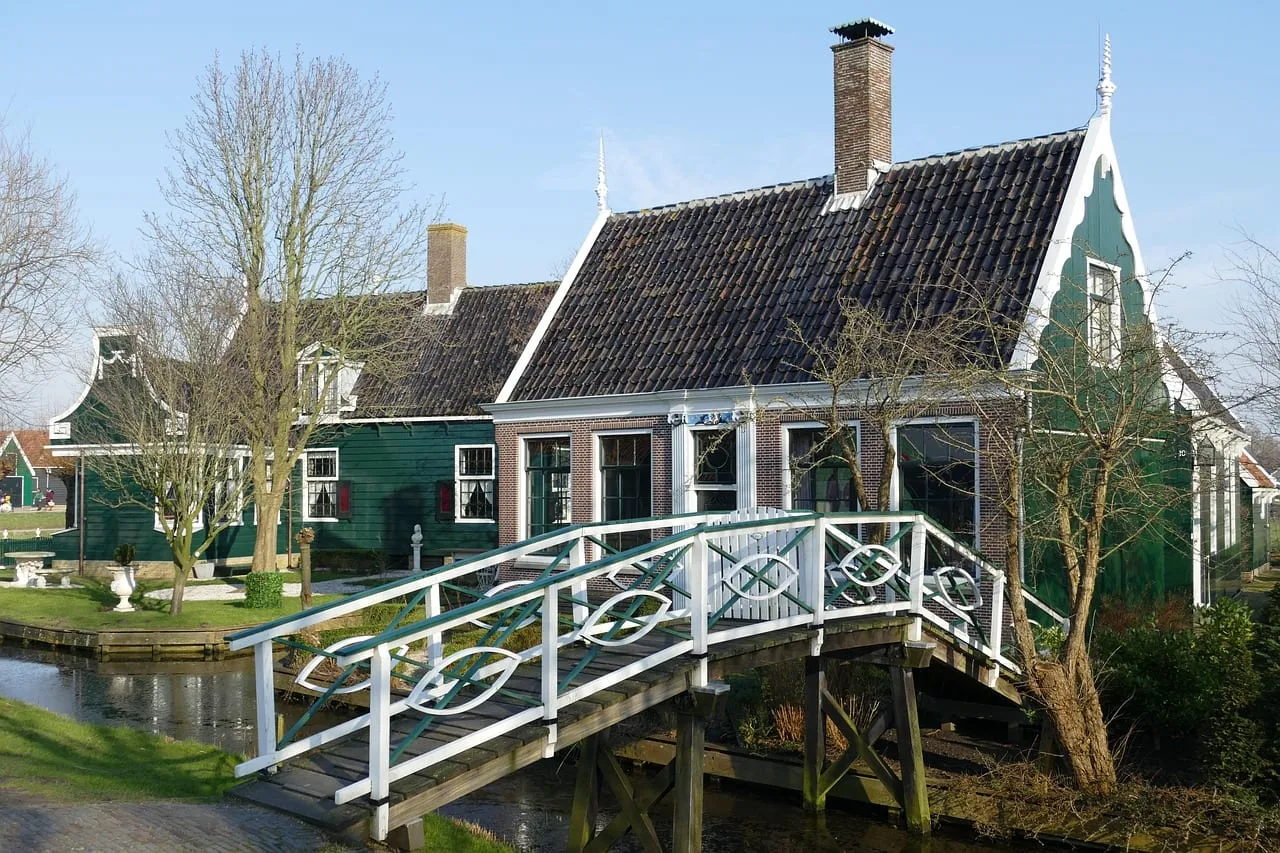 Green wooden houses and a white footbridge